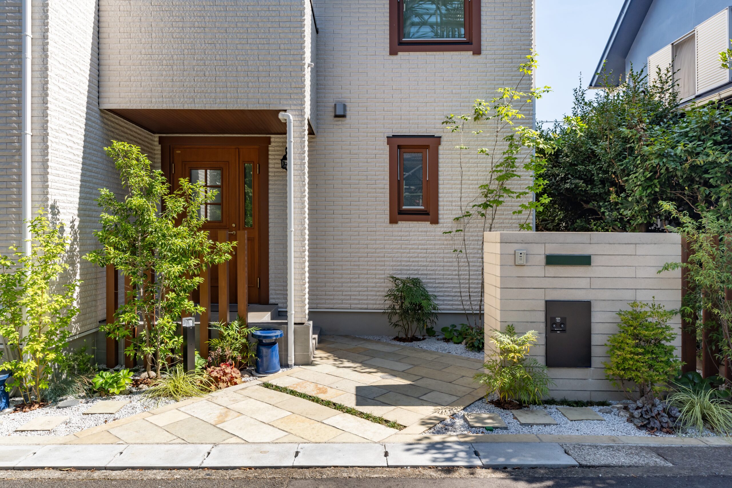 緑と自然石敷きアプローチが迎える温かな門まわり